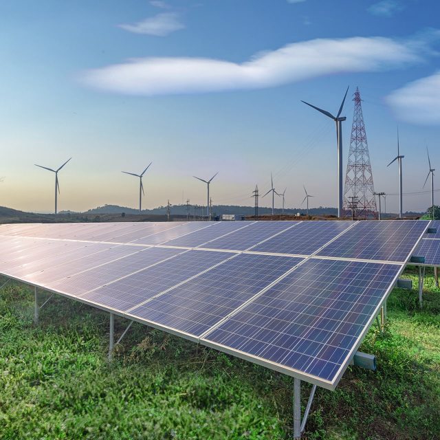 renewable-energy-solar-panels-wind-turbines-green-grass-blue-sky