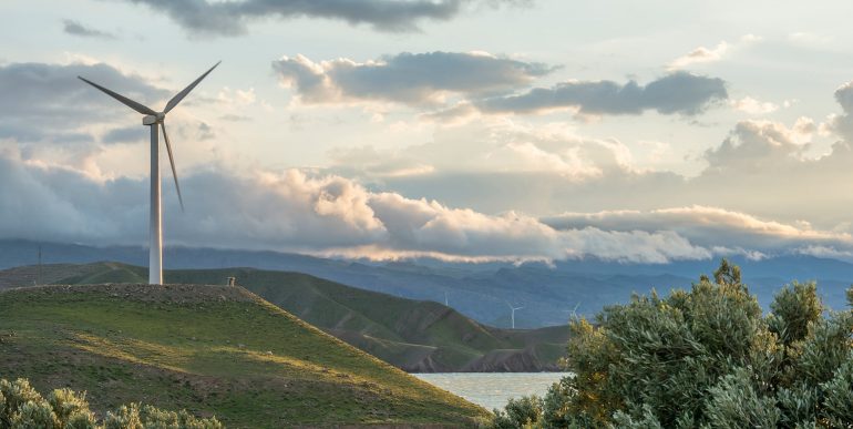 wind-power-turbine-hill-front-cloudy-sky